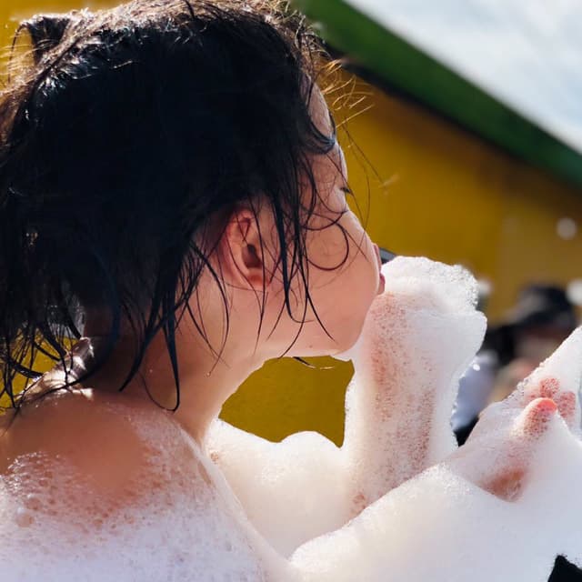 真木保育園のプールの泡を口で吹いている女の子